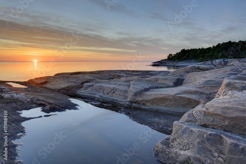 Rocky coast at sunset, Djuro National Park, Sweden photo