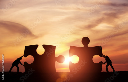 Teamwork concept. Two businessman connecting puzzle pieces photo