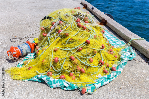 Heap of yellow fishnet on ground at sea © benschonewille