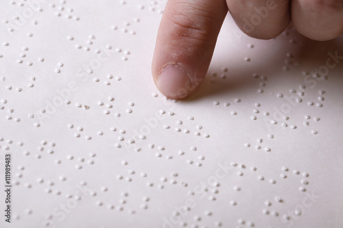 Blind person touching book, written in braille writing