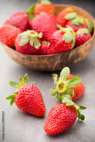 Strawberry in a bowl on the gray background.