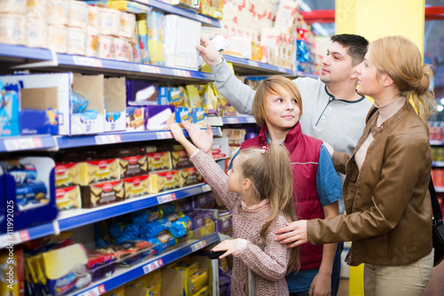 Family choosing cereal in supermarket.