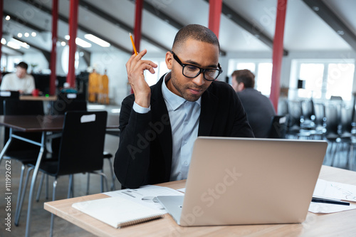 Serious businessman working with laptop