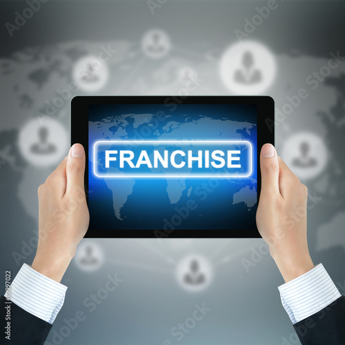 FRANCHISE sign on tablet pc screen held by businessman hands