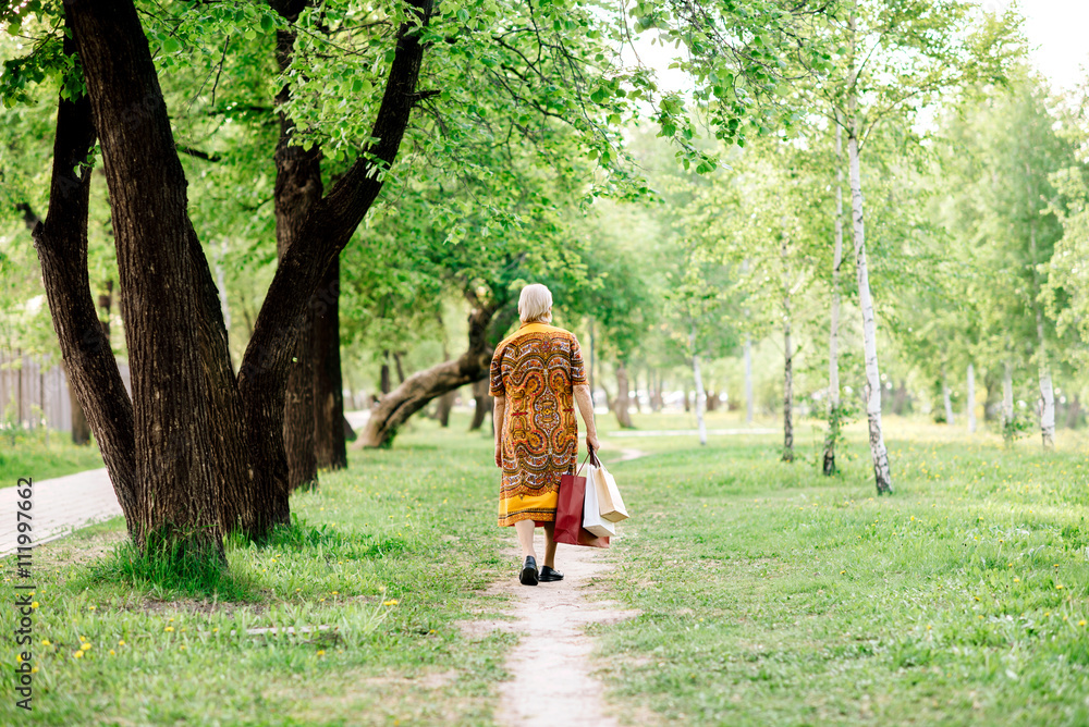 Fototapeta premium the grandmother comes back from shop with purchases