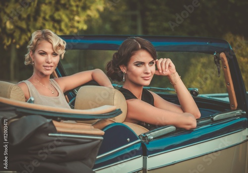 Two stylish ladies in a classic convertible