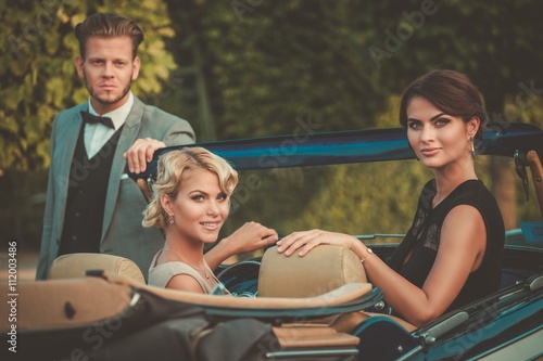 Wealthy friends in a classic convertible © Nejron Photo