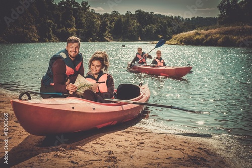 Group of people on kayaks reading map © Nejron Photo