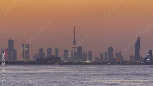 Skyline with Skyscrapers day to night timelapse in Kuwait City downtown illuminated at dusk. Kuwait City, Middle East photo