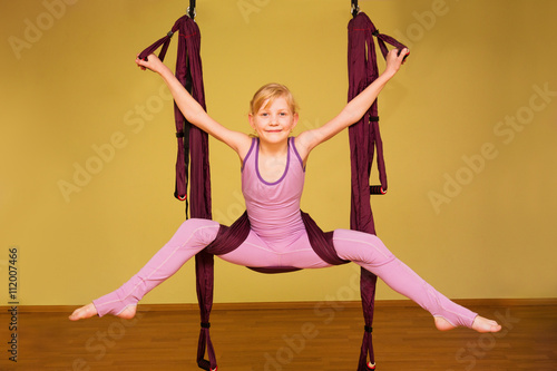 Little girl making aerial yoga exercises, indoor