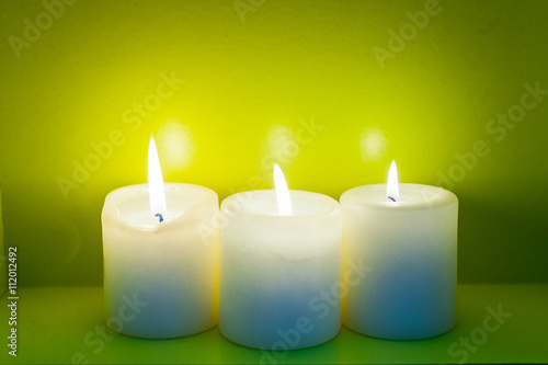 Colorful scented candles on a dark green background