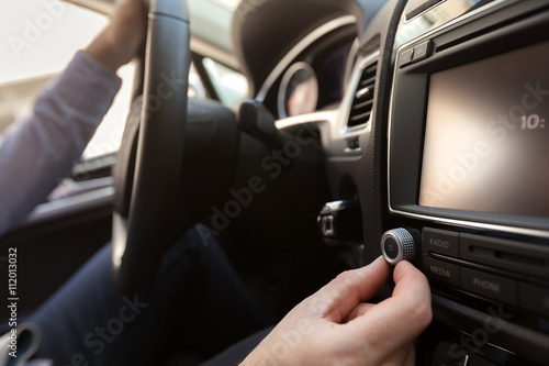 Hand Pushing the power button to turn on the car stereo system