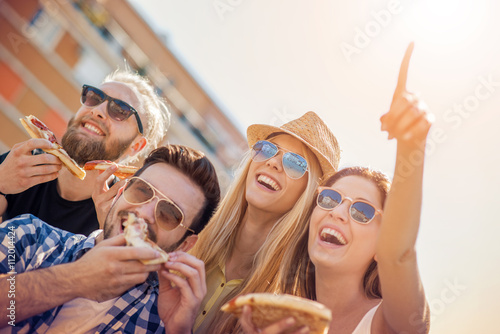 Group of friends taking their slices of pizza