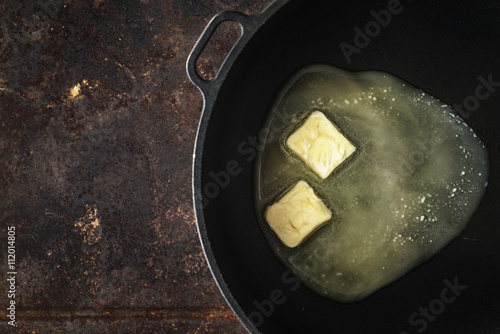 Pieces of butter in the hot pan top view