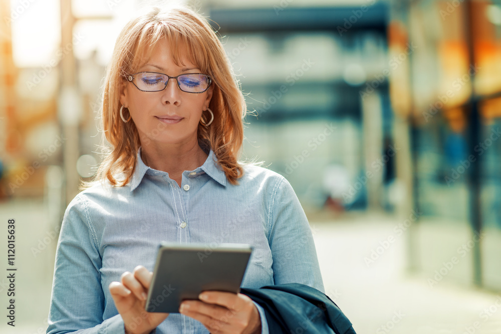 Mature businesswoman using digital tablet Mature businesswoman using digital tablet