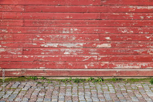 Old red wooden wall and cobblestone floor