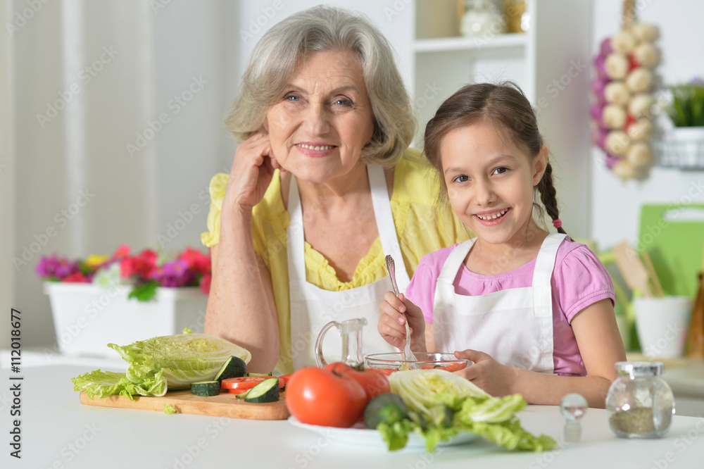 Senior woman with granddaughter cooking Senior woman with granddaughter cooking