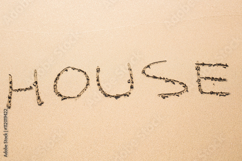 word house written in sand on beach