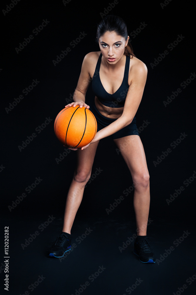 Beautiful focused sportswoman with ball ready to play basketball