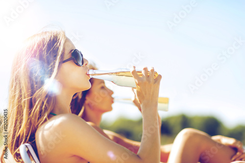 Photography girls with drinks on the beach chairs