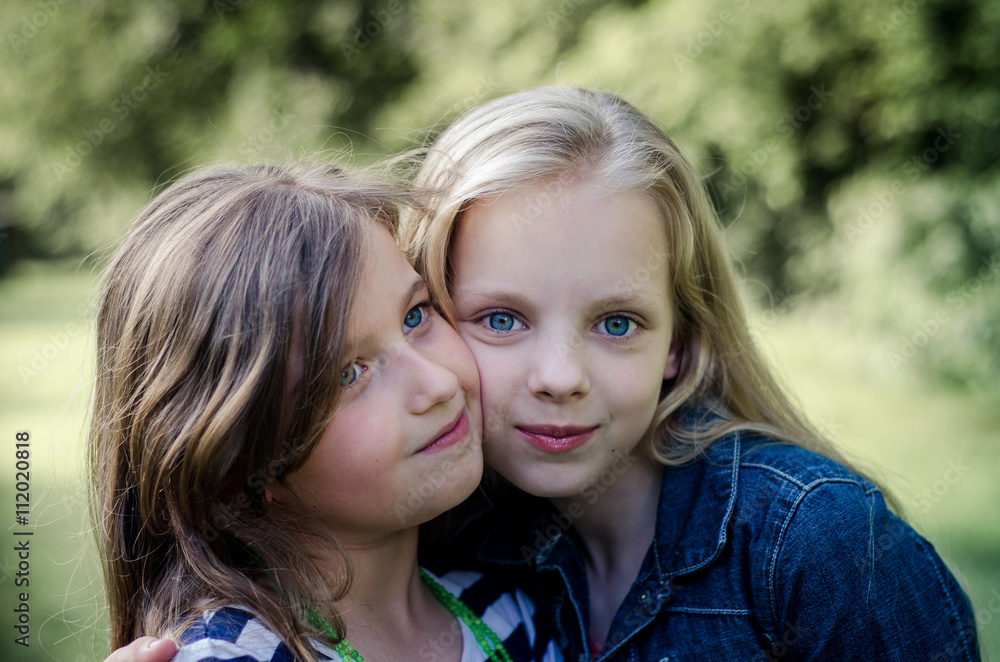Portrait of two long haired preteen girls while smiling. Portrait of two long haired preteen girls while smiling.