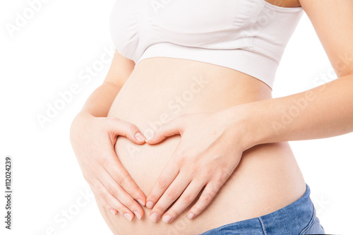 Close-up of woman embracing her pregnant belly