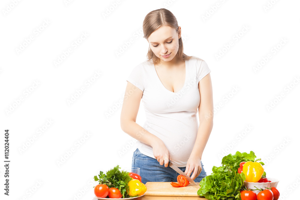 pregnant woman cutting tomato in studio pregnant woman cutting tomato in studio