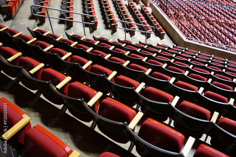 Naklejka premium Folded red seats at a multipurpose arena and sports stadium