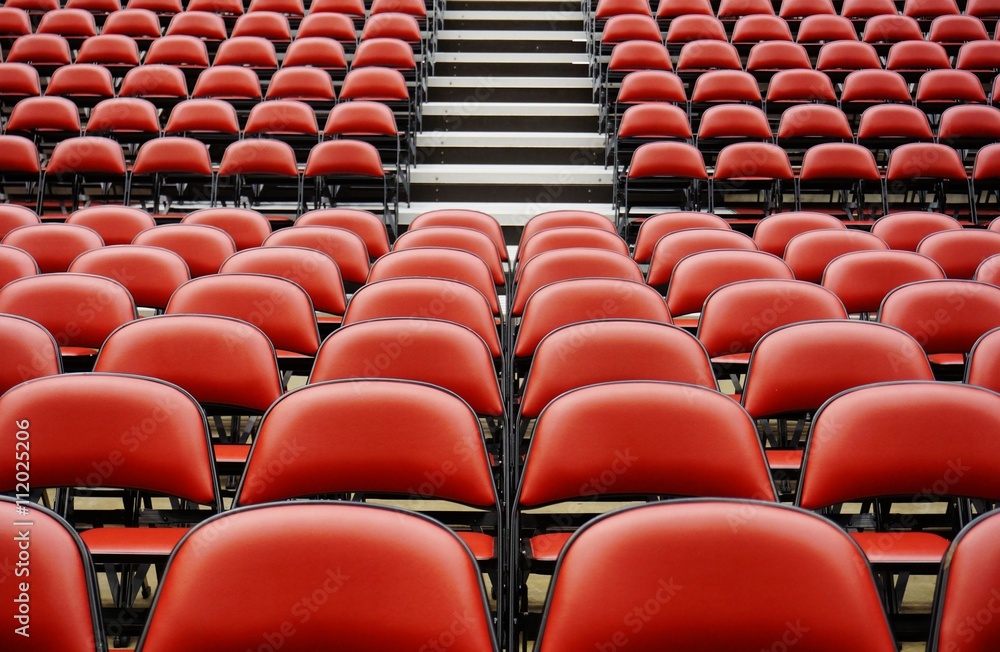 Naklejka premium Folded red seats at a multipurpose arena and sports stadium