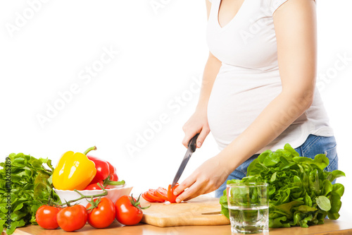 Close-up of pregnant woman cutting tomato © julenochek