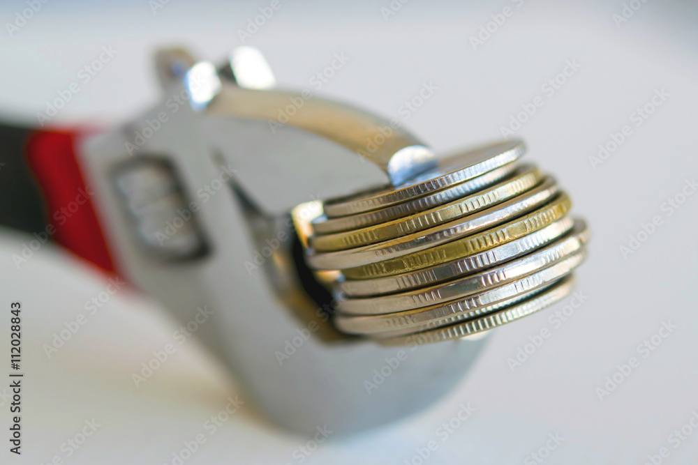 Wrench and coins . The concept of financial reliability . Wrench and coins . The concept of financial reliability .