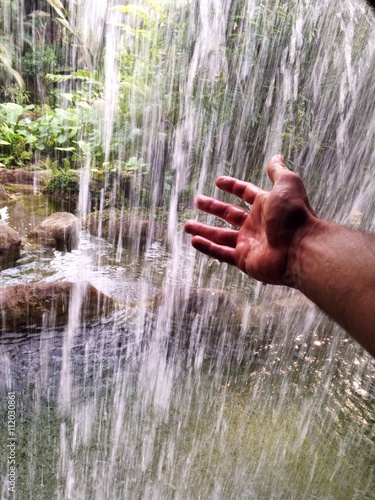 Hand reaching for waterfall