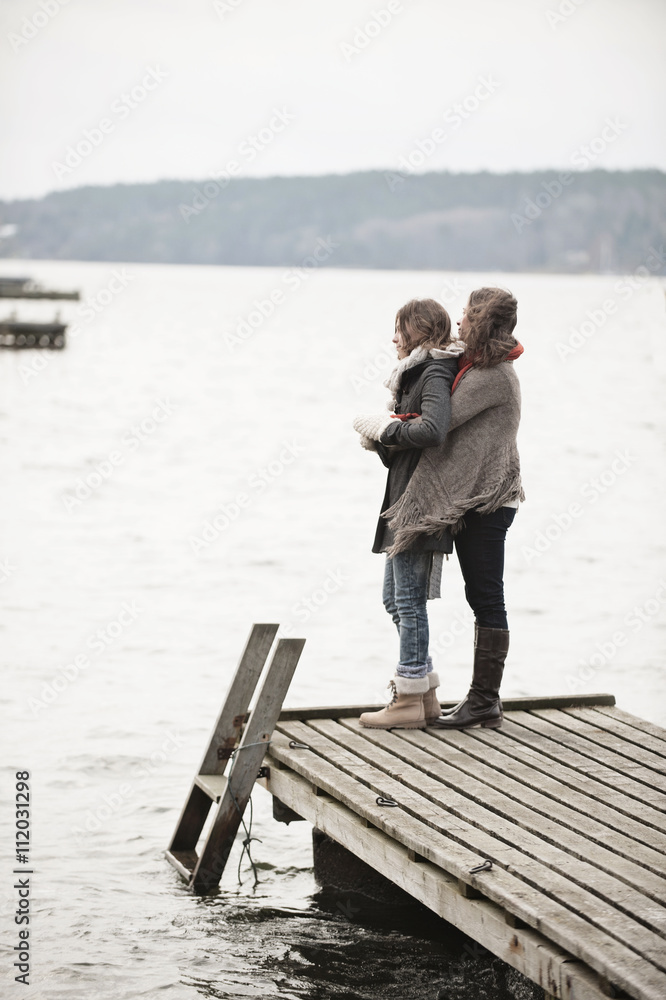 Mother and teenage daughter looking at water Mother and teenage daughter looking at water