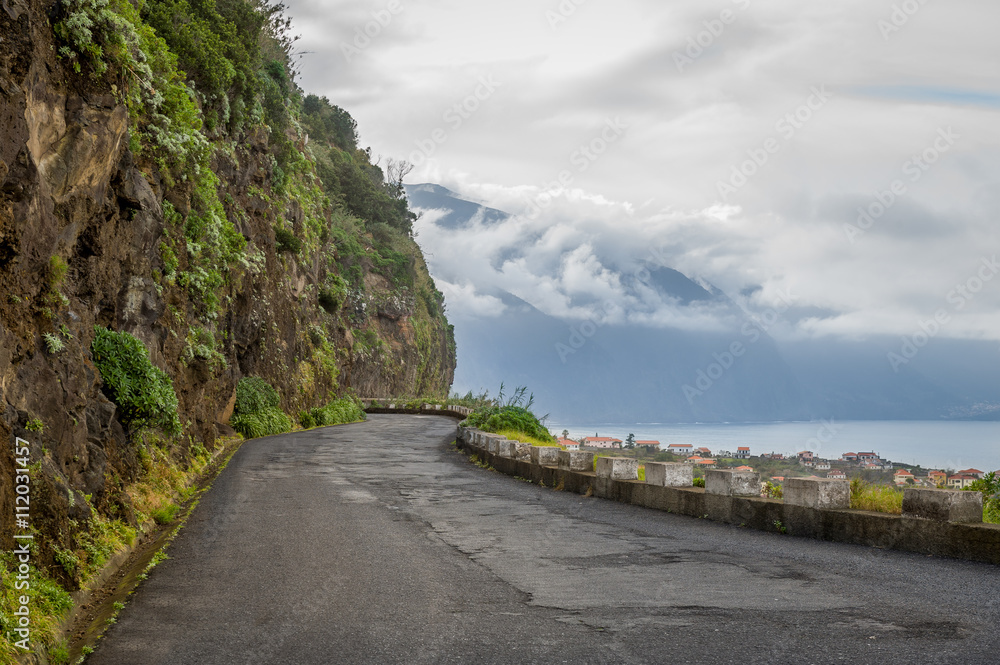Old mountain road between mountains and ocean at Madeira island.