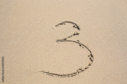 The numbers three written in the sand. © satura_