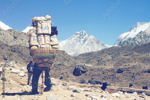 Sherpa carrying a large load on his back photo