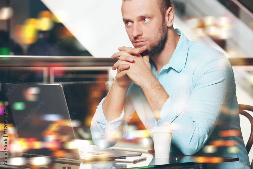 Young businessman having lunch and working in a cafe on blurred background Young businessman having lunch and working in a cafe on blurred background
