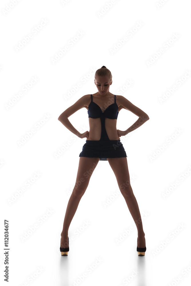 Beautiful slim go-go dancer in black dress with wide legs looking down