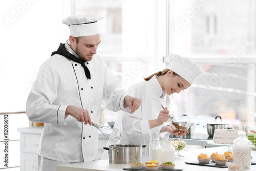 Male and female chefs worki...