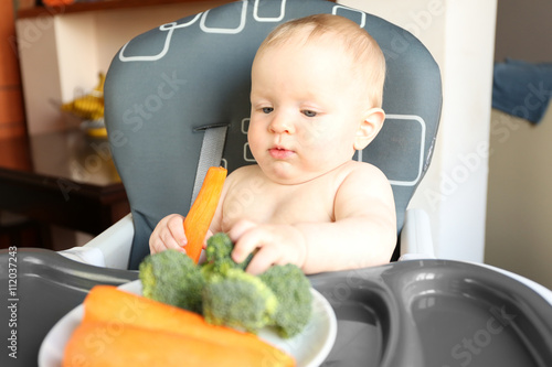 Baby eating vegetables in a...