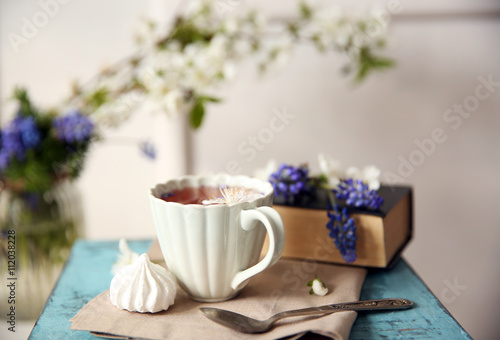Cup of tea with flowers on wooden stool © Africa Studio
