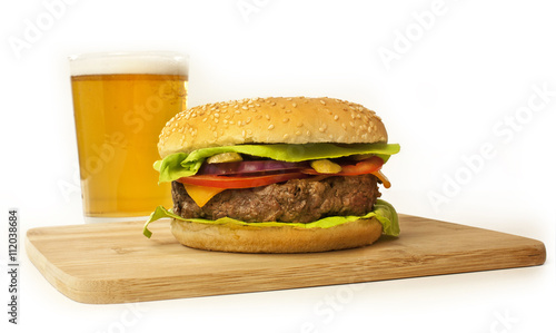 Meet burger on wooden board with blurred beer in background