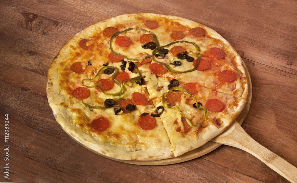 Pepperoni pizza with salami and peppers on pizza stone Pepperoni pizza with salami and peppers on pizza stone