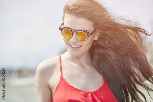 Young woman on the beach in hot summer sun light