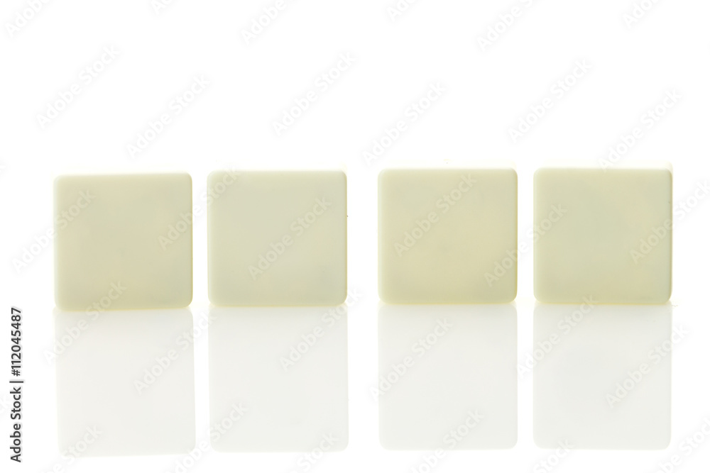 Four blank plastic tile pieces for text in a row, isolated on a white background Four blank plastic tile pieces for text in a row, isolated on a white background