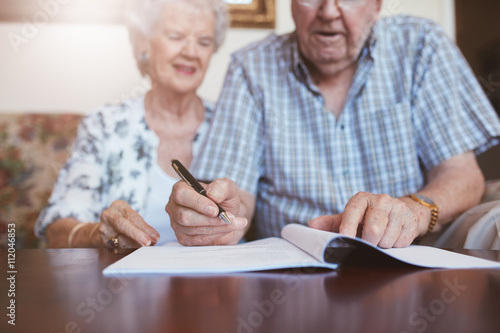 Senior couple signing their will documents photo