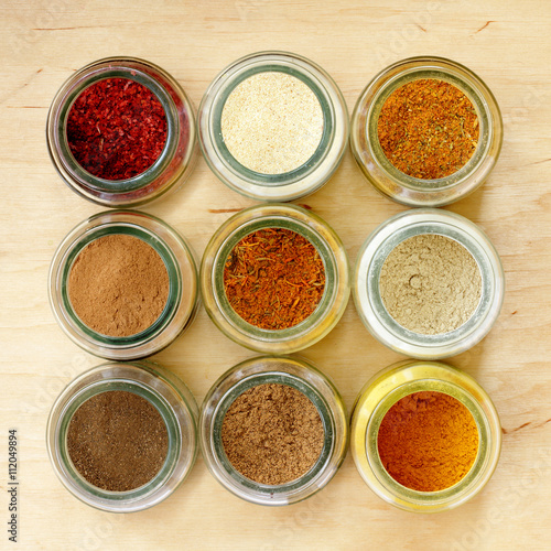 aromatic seasoning for cooking in the kitchen/ many different spices in glass jars, and a special seasoning for pilaf in the middle of a top view 