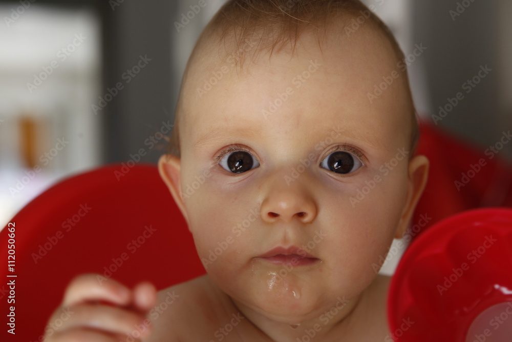 Close up angled view on front of fascinated cute little baby with wide eyes and mesmerized expression. Close up angled view on front of fascinated cute little baby with wide eyes and mesmerized expression.