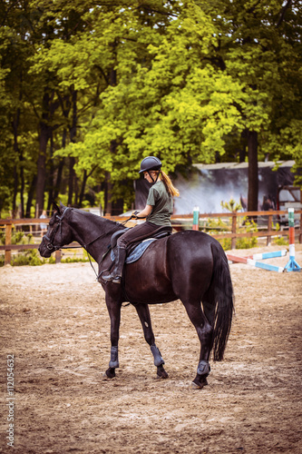 girl sportsman rides on horse