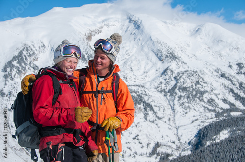 Summit Love 20's couple on mountain peak embracing
